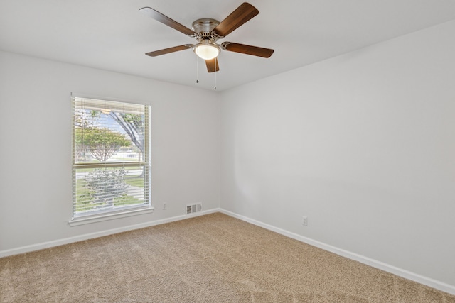 carpeted spare room featuring ceiling fan