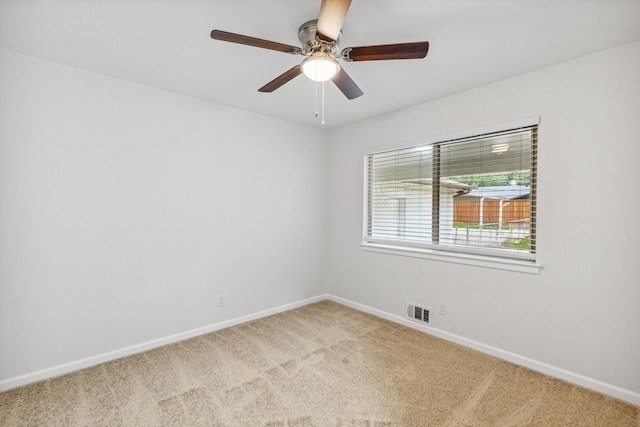 carpeted spare room with ceiling fan