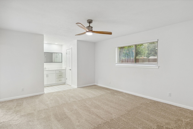 carpeted spare room featuring ceiling fan