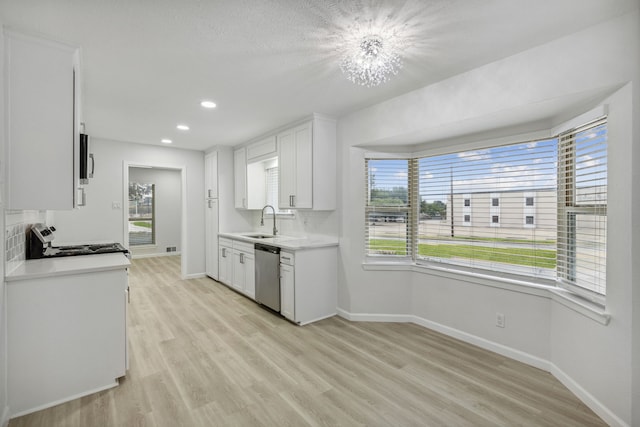 kitchen with stainless steel appliances, white cabinetry, a wealth of natural light, and sink