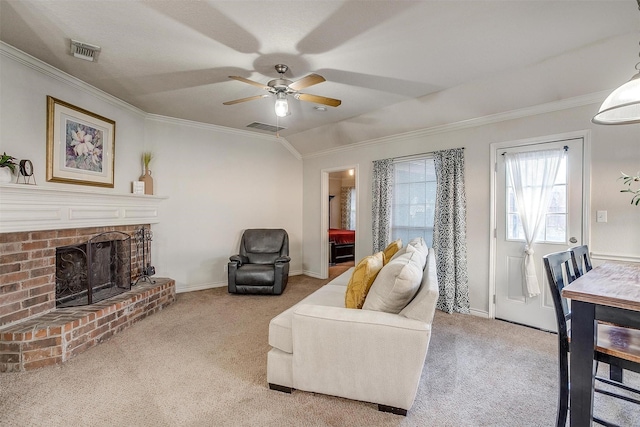 carpeted living room with ceiling fan, ornamental molding, lofted ceiling, and a brick fireplace