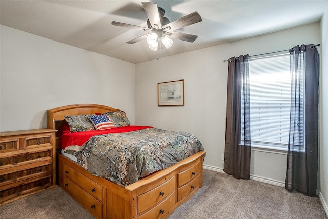 carpeted bedroom with ceiling fan and multiple windows