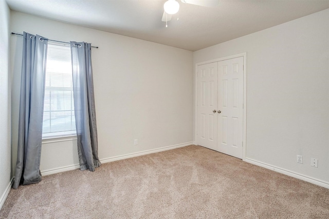 spare room featuring light colored carpet and ceiling fan