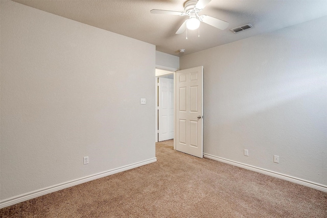 spare room featuring ceiling fan and light colored carpet