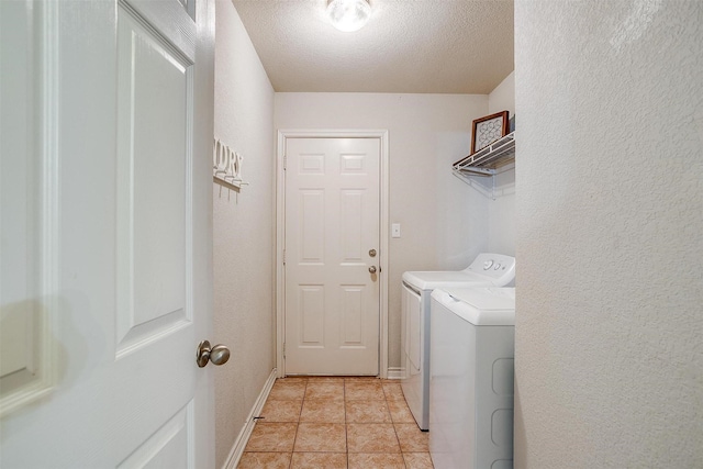 laundry room with separate washer and dryer, a textured ceiling, and light tile patterned floors