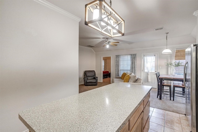 kitchen with light carpet, stainless steel fridge, ornamental molding, ceiling fan with notable chandelier, and pendant lighting