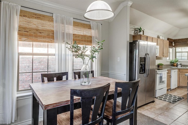 dining space featuring light tile patterned floors, vaulted ceiling, ornamental molding, and sink