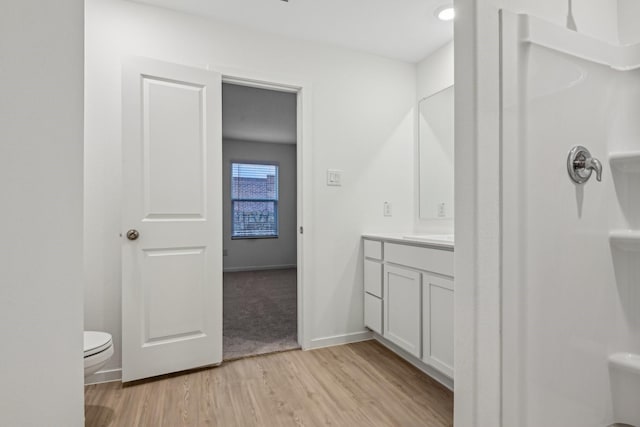 bathroom featuring walk in shower, vanity, toilet, and hardwood / wood-style floors