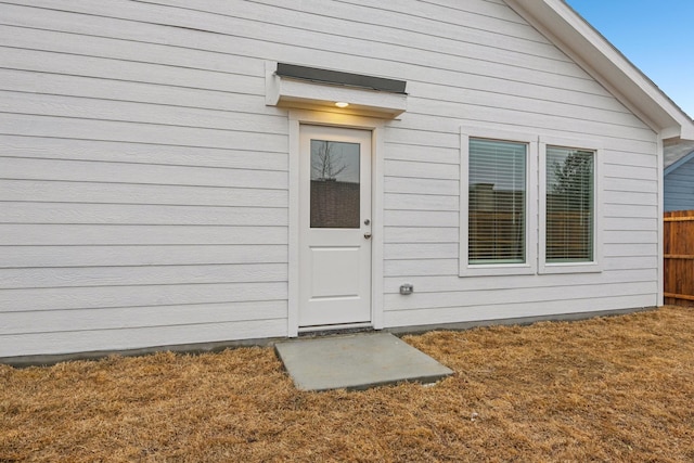 view of exterior entry featuring a lawn