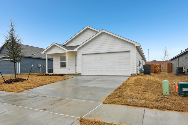 ranch-style home with a garage and central AC unit