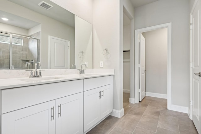 bathroom with tile patterned floors, vanity, and a shower with shower door