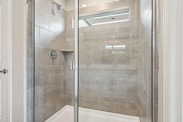 bathroom featuring a shower with door