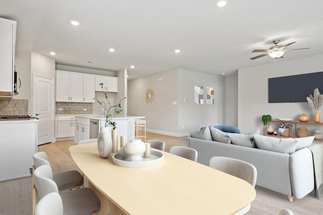 dining area with light hardwood / wood-style floors and ceiling fan