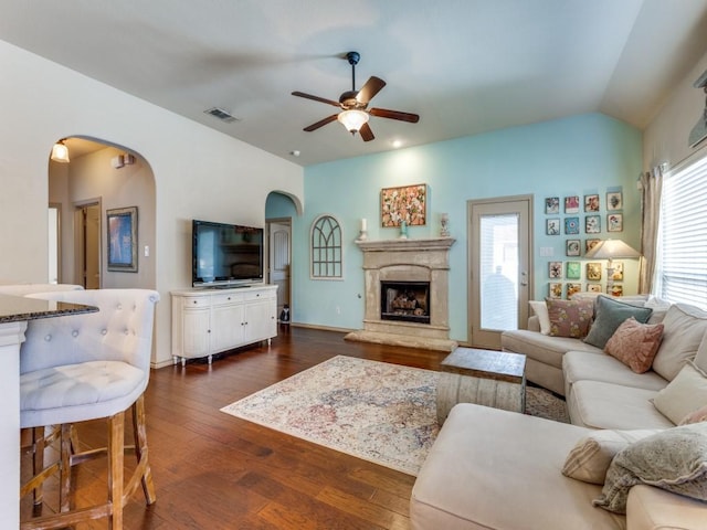 living room featuring ceiling fan, dark hardwood / wood-style flooring, and vaulted ceiling