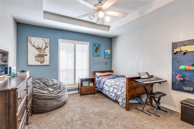 bedroom featuring carpet flooring, ceiling fan, and a tray ceiling