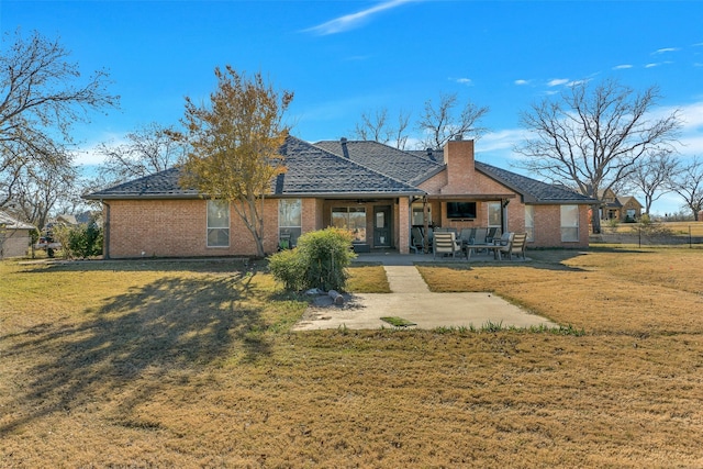 rear view of property with a patio and a lawn