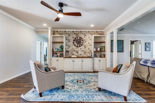 living room with dark hardwood / wood-style flooring, decorative columns, a textured ceiling, ceiling fan, and crown molding