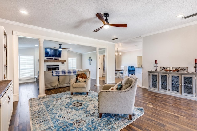 living room with a fireplace, a textured ceiling, crown molding, and dark wood-type flooring