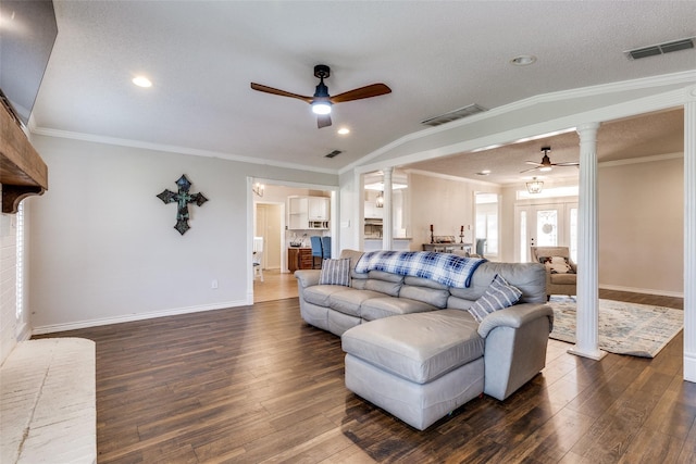 living room featuring ornate columns, ceiling fan, dark hardwood / wood-style floors, and ornamental molding