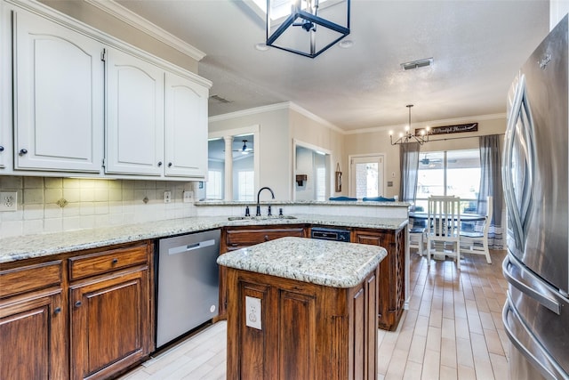 kitchen featuring a center island, sink, a healthy amount of sunlight, and stainless steel appliances