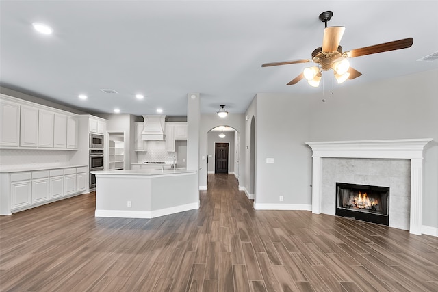 kitchen featuring appliances with stainless steel finishes, premium range hood, white cabinetry, and light hardwood / wood-style floors