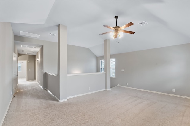 carpeted spare room featuring ceiling fan and vaulted ceiling