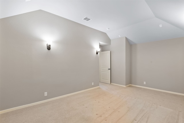 unfurnished room with light carpet and vaulted ceiling