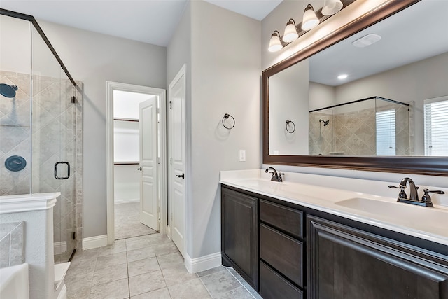 bathroom featuring tile patterned flooring, vanity, and walk in shower