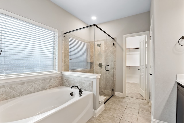 bathroom with shower with separate bathtub, vanity, tile patterned floors, and a wealth of natural light