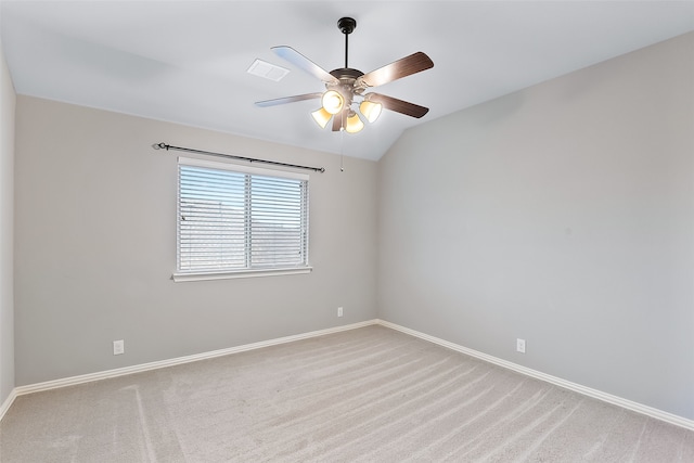 empty room featuring light carpet, ceiling fan, and vaulted ceiling