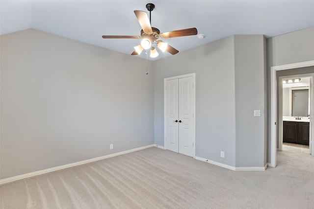 unfurnished bedroom with light carpet, ceiling fan, sink, a closet, and lofted ceiling