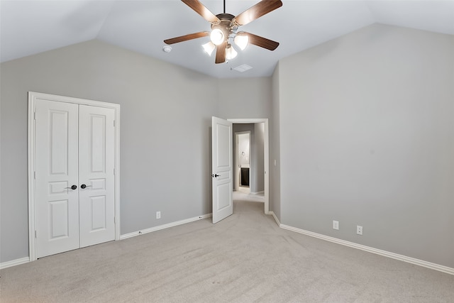 unfurnished bedroom with light colored carpet and lofted ceiling