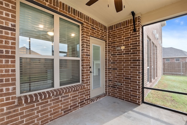 unfurnished sunroom with ceiling fan