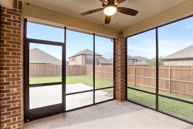 unfurnished sunroom with ceiling fan