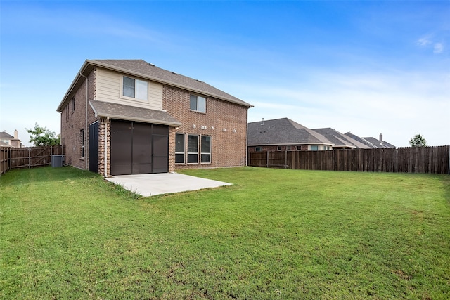 rear view of property with a yard, a patio, and central air condition unit