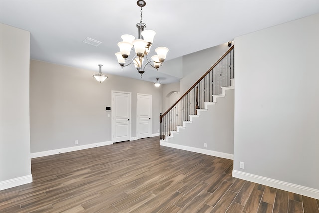 foyer entrance with a chandelier and dark wood-type flooring