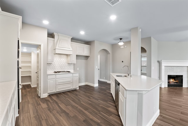 kitchen featuring sink, dark hardwood / wood-style floors, custom range hood, white cabinetry, and stainless steel appliances