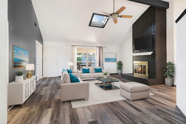 living room featuring ceiling fan, a brick fireplace, dark hardwood / wood-style flooring, high vaulted ceiling, and beamed ceiling