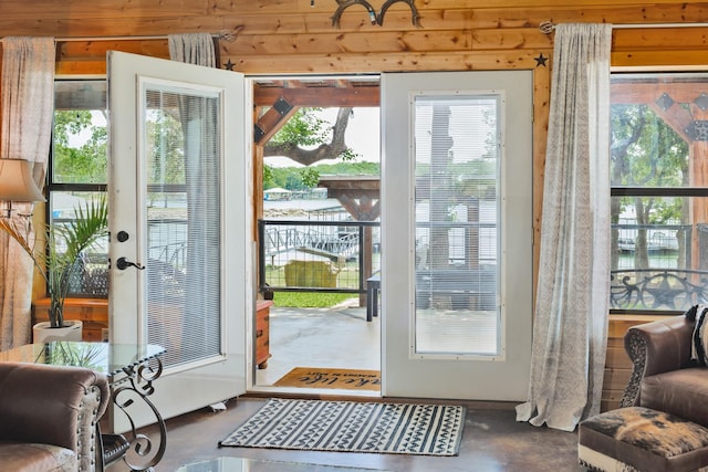 doorway to outside featuring concrete flooring and a wealth of natural light