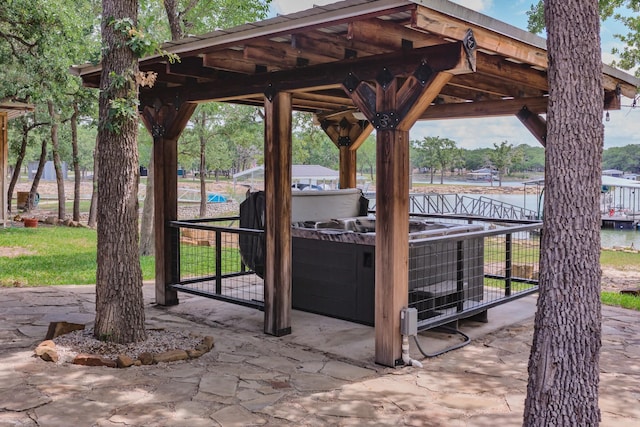 view of patio / terrace with a water view and a hot tub