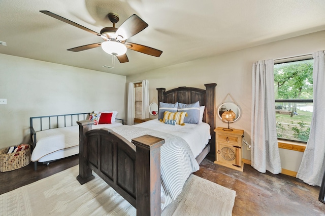 bedroom with ceiling fan and concrete flooring