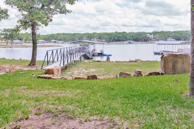 dock area featuring a lawn and a water view