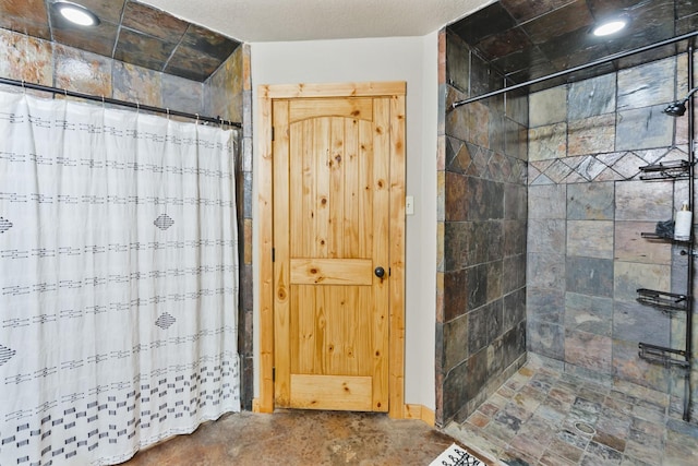 bathroom with a textured ceiling and walk in shower