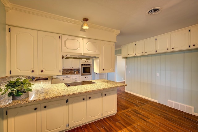 kitchen featuring dark wood-type flooring, white cabinetry, stainless steel oven, ornamental molding, and light stone countertops