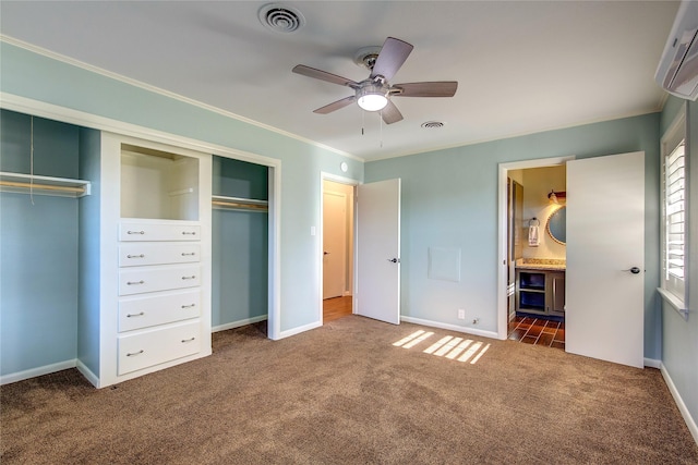 unfurnished bedroom featuring ensuite bathroom, dark carpet, ceiling fan, and crown molding