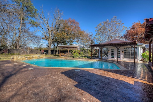 view of swimming pool with pool water feature, a patio, and french doors