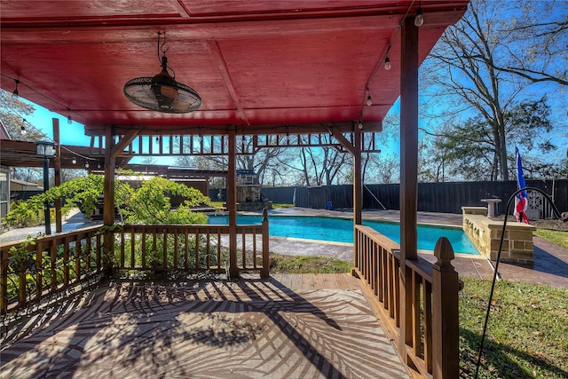 view of swimming pool featuring ceiling fan and a deck