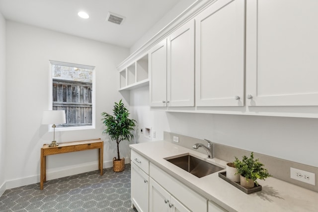 interior space featuring white cabinetry and sink