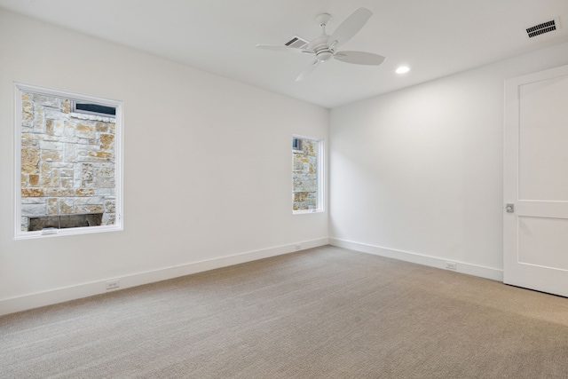 unfurnished room with ceiling fan and light carpet