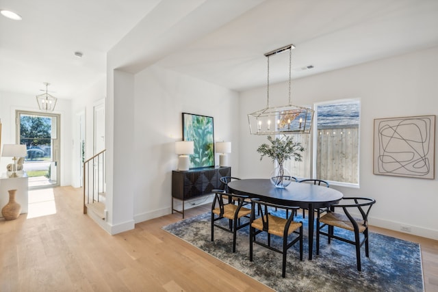 dining space featuring light hardwood / wood-style floors and an inviting chandelier